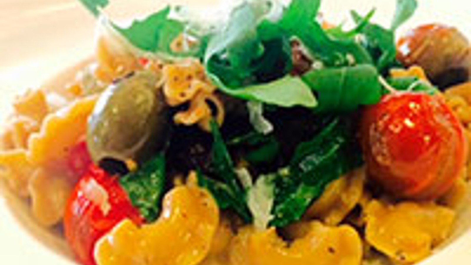 Whole grain pasta with olives, tomatoes and arugula