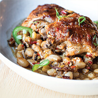 Braised chicken thighs with barbecued white beans and scallions