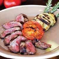 Lucky Dog Ranch New York strip steak with grilled Yukon Gold potatoes and fire-roasted tomato