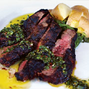 Grilled flatiron steak with roasted potatoes, sautéed spinach and chimichurri sauce